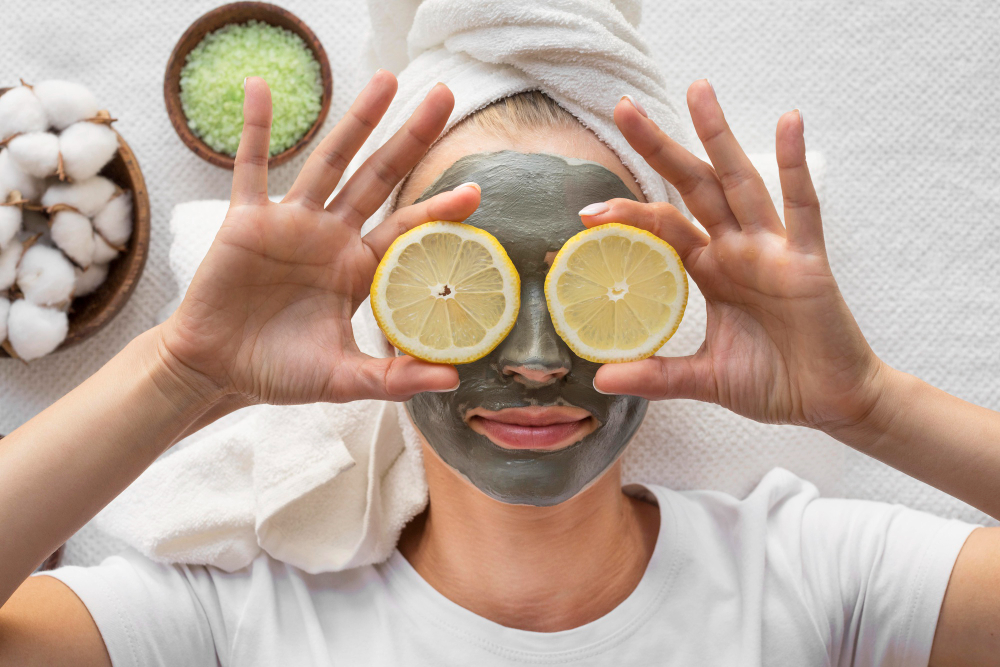 Femme avec masque facial et tranches de citron sur les yeux.