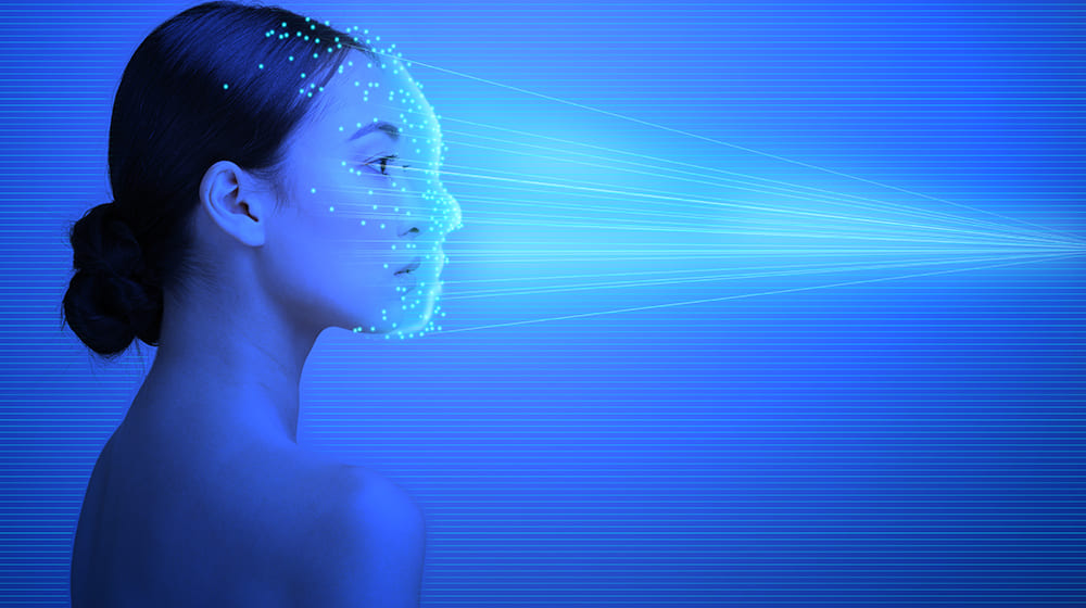 Femme de profil avec points lumineux sur le visage en fond bleu.