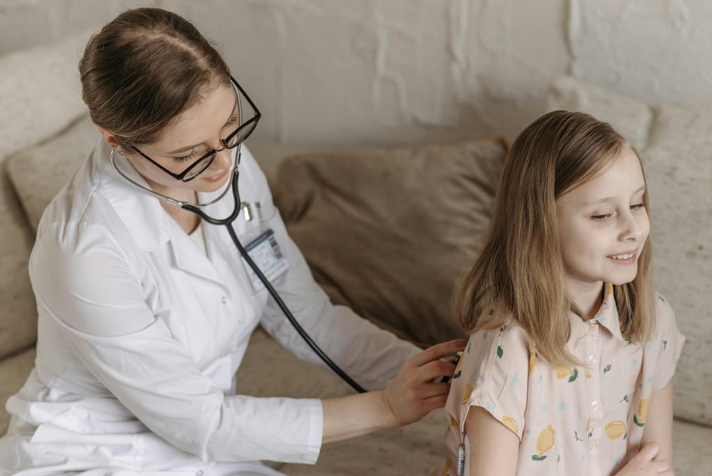 Médecin auscultant une jeune fille avec un stéthoscope.